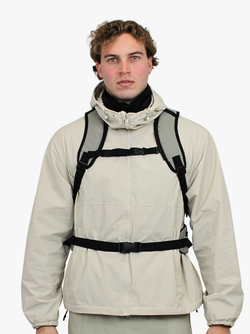 Grå funktionel rygsæk på ryg med justerbart brystspænde