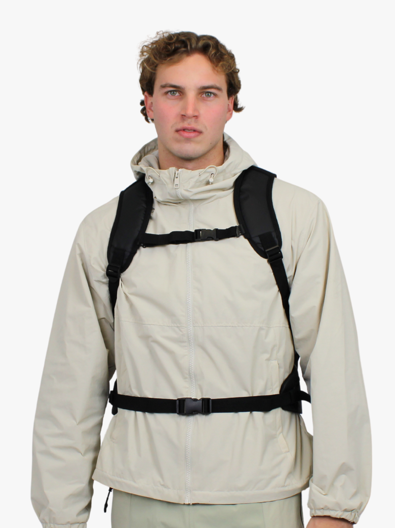 Sort teknisk daypack på ryg med justerbart brystspænde til vandring